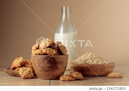 Oatmeal cookies and milk sit on a kitchen table. Oatmeal cookies and milk sit on a kitchen table. 134271803
