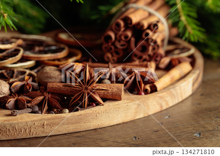 Spices and branches of Christmas tree on an old wooden table. Spices and branches of Christmas tree on an old wooden table. 134271810
