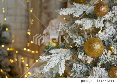 Snowy Christmas tree with shining golden ball. Winter holiday decoration. New year celebration background for copy space. 134271844