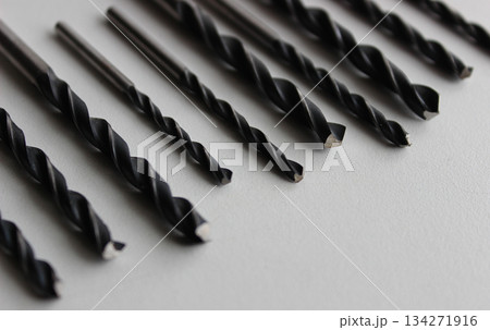 Metal Drill Bits On Clean White Plastic Surface Closeup Angle View  134271916