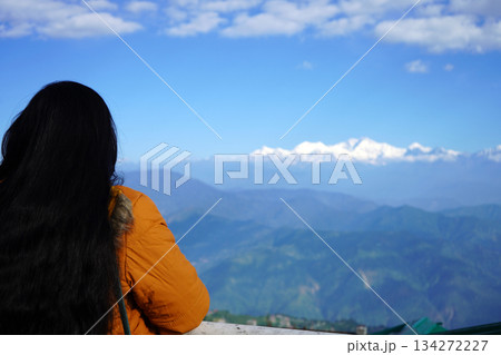 Young woman looking at snowcapped Himalayan mountain peaks from a scenic viewpoint at Darjeeling 134272227