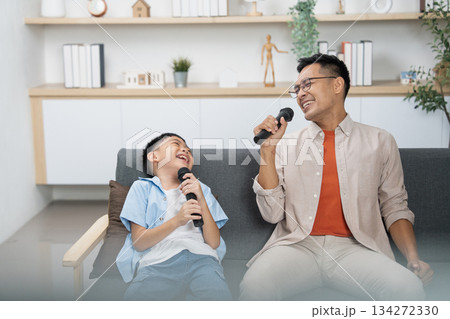 Father and son enjoying karaoke, sharing laughter and joy Father and son enjoying karaoke, sharing laughter and joy 134272330