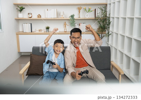 Father and son celebrating victory in video game together Father and son celebrating victory in video game together 134272333