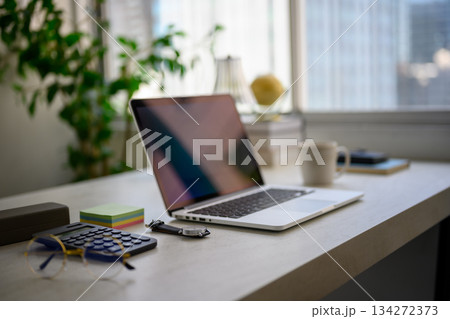 窓際の明るいデスクで作業準備：ノートPCと文房具 134272373