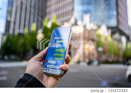 屋外でスマホのメッセージを確認 屋外でスマホのメッセージを確認 134272383