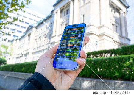屋外で株価アプリを見る手元 屋外で株価アプリを見る手元 134272418