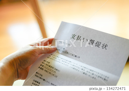 督促状を持つ手元 134272471