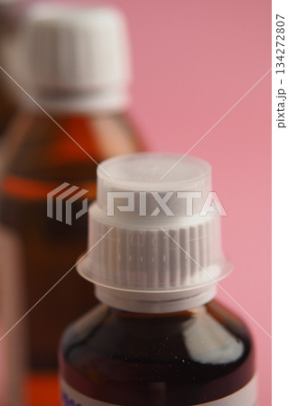 Close-up view of medicine bottles on pink background 134272807
