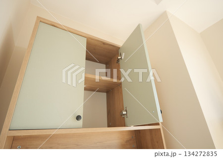 Cabinet with open doors showing empty shelves inside Cabinet with open doors showing empty shelves inside 134272835