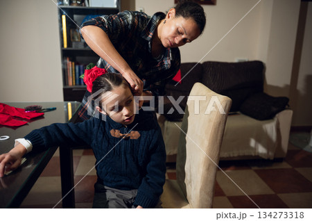Mother Styles Daughter Hair At Home: Warm Bonding Moment During Christmas Time 134273318