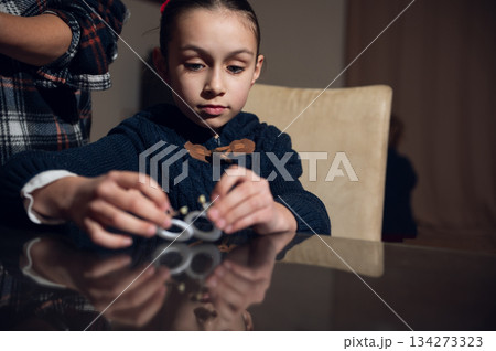 Girl Crafts Jewelry Rings At Table In Cozy Indoor Scene 134273323