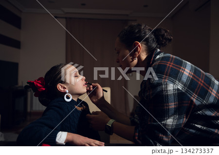 Mother Applies Lipstick To Daughter In Cozy Home Setting During Quiet Beauty Moment Mother Applies Lipstick To Daughter In Cozy Home Setting During Quiet Beauty Moment 134273337