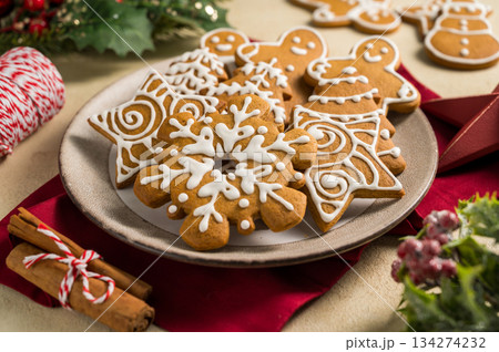 Holiday background. Christmas gingerbread cookies with icing in a plate, festive food Holiday background. Christmas gingerbread cookies with icing in a plate, festive food 134274232