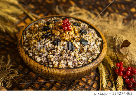 Kutya began the celebration of Christmas in Ukraine. Kutia with poppy seeds and honey. Christmas porridge kutya over wooden background. Kutya began the celebration of Christmas in Ukraine. Kutia with poppy seeds and honey. Christmas porridge kutya over wooden background. 134274462
