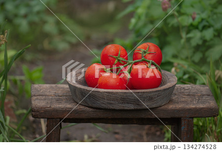 Red round tomatoes in a bowl on wooden background. Cottagecore style aesthetic 134274528