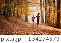 紅葉の森を走る2人 134274579