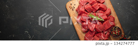Diced cut raw beef cubes wooden cutting board red meat cooking protein top view copy space Diced cut raw beef cubes wooden cutting board red meat cooking protein top view copy space 134274777