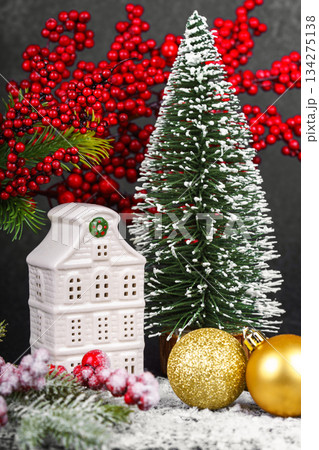 Ceramic Christmas house with pine Tree and winter gold decorations on black background with snow 134275138