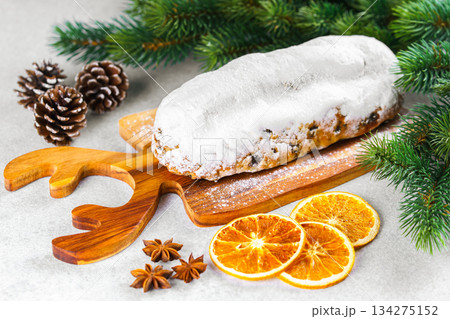 Traditional Christmas Stollen, sweet fruit loaf with sugar icing on wooden board and festive decor Traditional Christmas Stollen, sweet fruit loaf with sugar icing on wooden board and festive decor 134275152