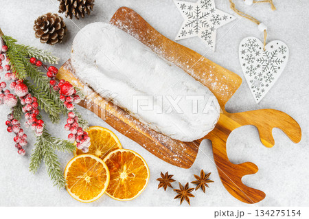 Traditional Christmas Stollen, sweet fruit loaf with sugar icing on wooden board and festive decor Traditional Christmas Stollen, sweet fruit loaf with sugar icing on wooden board and festive decor 134275154