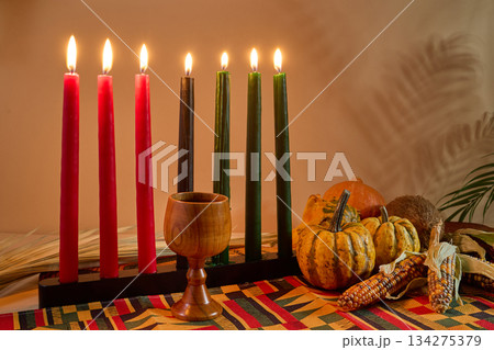 Kwanzaa Celebration Display. A traditional Kwanzaa setup with candles, fruits, and a wooden cup 134275379