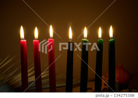 Candle Arrangement. Seven colorful candles lit in a dark, warm atmosphere. 134275386