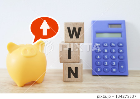 WINブロックと貯金箱で示す貯蓄アップと資産形成の成功。 WINブロックと貯金箱で示す貯蓄アップと資産形成の成功。 134275537