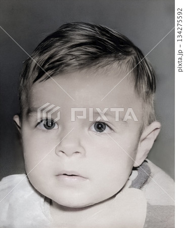 A vintage portrait of an enthusiastic one-year-old girl wearing a bib while eating. Retro photo from 1995. 134275592