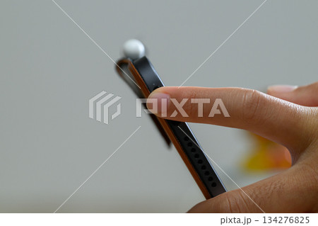 タブレットのスピーカーとサイドボタンを操作する指 134276825