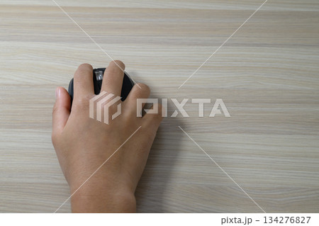 ワイヤレスマウスと木目調のデスク 134276827