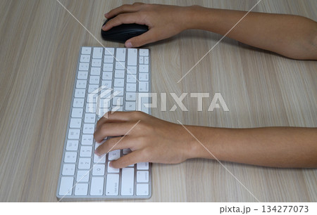 マウス操作とキーボード入力を行う手元 134277073