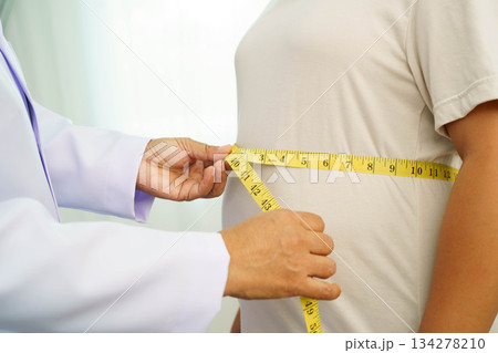 Asian woman with fat belly big size overweight and obesity with measure tape. 134278210