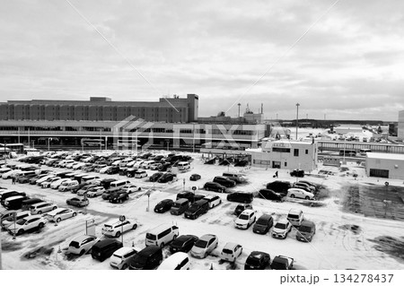 国内線ターミナルをバックに雪が積もった「北海道新千歳空港」B駐車場「白黒」 134278437