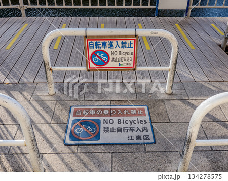 歩行者専用通路への自転車進入禁止を告知する看板とバリケード 134278575