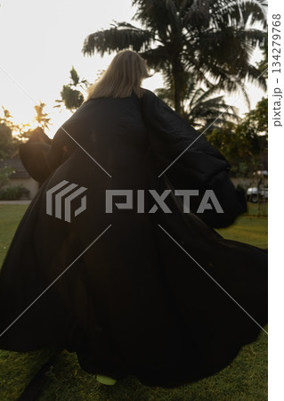 A beautiful Caucasian blonde is walking in nature wearing a black hat. The luxury of the territory of an expensive hotel. A beautiful Caucasian blonde is walking in nature wearing a black hat. The luxury of the territory of an expensive hotel. 134279768