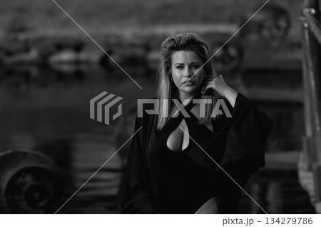 A beautiful Caucasian blonde is walking in nature wearing a black hat. A beautiful Caucasian blonde is walking in nature wearing a black hat. 134279786