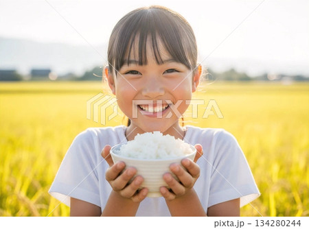 農園でお米を両手ですくう笑顔の女の子　自然体の収穫体験 134280244