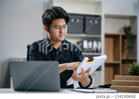 Young businessman working with working notepad, tablet and laptop documents talking on the smartphone, tablet and laptop 134280608