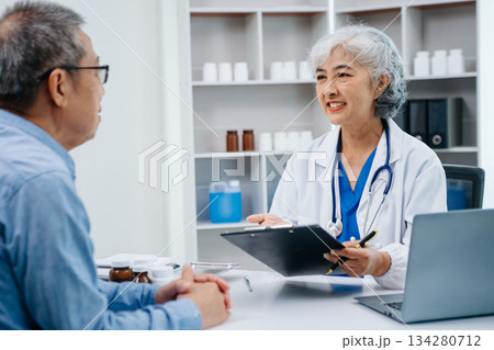 Asian female hands touching senior male hand Helping hands holding bottle with pills in hands, reading instruction take care Asian female hands touching senior male hand Helping hands holding bottle with pills in hands, reading instruction take care 134280712