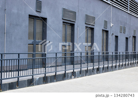 Industrial gray exterior, Urban scene featuring minimalist architecture and stark midday shadows Industrial gray exterior, Urban scene featuring minimalist architecture and stark midday shadows 134280743