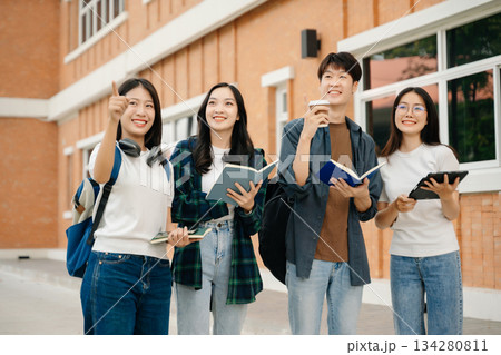 Young Asian People college students and a female student group work at the campus park in morning with her friend Young Asian People college students and a female student group work at the campus park in morning with her friend 134280811