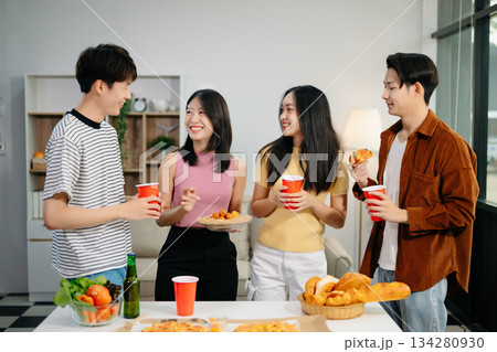 Young Asian friend having, enjoy evening party together at home. Attractive young man and woman having fun, eating food, celebrate at home Young Asian friend having, enjoy evening party together at home. Attractive young man and woman having fun, eating food, celebrate at home 134280930