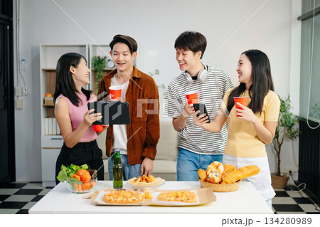 Young Asian friend having, enjoy evening party together at home. Attractive young man and woman having fun, eating food, celebrate at home 134280989