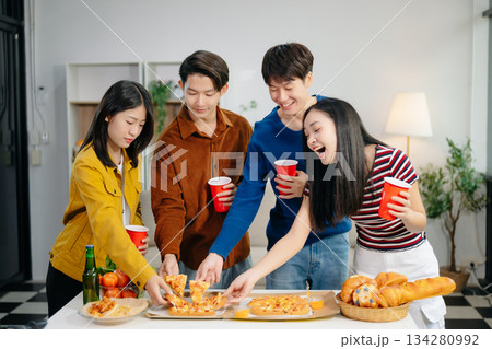 Young Asian friend having, enjoy evening party together at home. Attractive young man and woman having fun, eating food, celebrate at home Young Asian friend having, enjoy evening party together at home. Attractive young man and woman having fun, eating food, celebrate at home 134280992