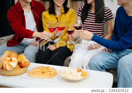 Young Asian friend having, enjoy evening party together at home. Attractive young man and woman having fun, eating food, celebrate at home 134281012