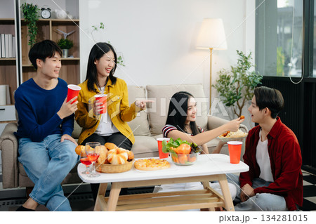 Young Asian friend having, enjoy evening party together at home. Attractive young man and woman having fun, eating food, celebrate at home 134281015