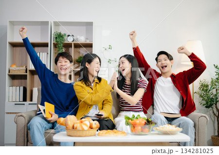 Young Asian friend having, enjoy evening party together at home. Attractive young man and woman having fun, eating food, celebrate at home Young Asian friend having, enjoy evening party together at home. Attractive young man and woman having fun, eating food, celebrate at home 134281025