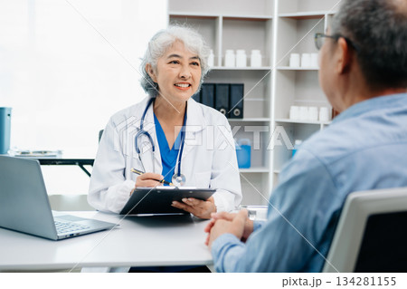 Asian female hands touching senior male hand Helping hands holding bottle with pills in hands, reading instruction take care 134281155