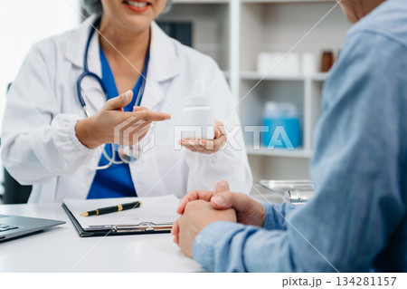Asian female hands touching senior male hand Helping hands holding bottle with pills in hands, reading instruction take care Asian female hands touching senior male hand Helping hands holding bottle with pills in hands, reading instruction take care 134281157
