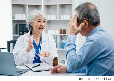 Asian female hands touching senior male hand Helping hands holding bottle with pills in hands, reading instruction take care 134281158